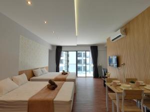 a hotel room with two beds and a table at Near Airport K Avenue Homestay by MINO Suites in Donggongon