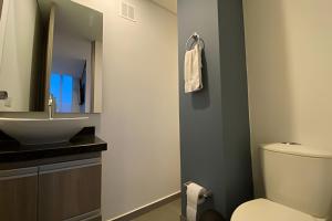 a bathroom with a white toilet and a sink at Domus Suites Chia in Chía +199 photos