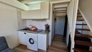 una cucina con lavatrice in una piccola stanza di Chez Michèle a Saint-François