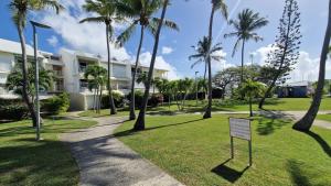 un parco con palme e un cartello davanti a un edificio di Chez Michèle a Saint-François
