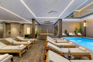 a hotel lobby with a pool and lounge chairs at AC Hotel by Marriott Stockholm Ulriksdal in Solna