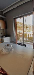 a table in a kitchen with a view of a balcony at Orsiida sea view apartment Agria in Agria +36 photos