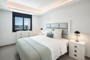 a white bedroom with a large bed and a window at Villa Angelique, 5 BDR with Heated Private Pool in Puerto Banus in Marbella +21 photos