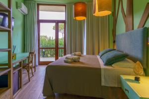 a bedroom with a bed and a table and a window at CSA Hotel Beach & Park in Marina di Bibbona +51 photos