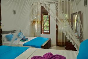 una camera da letto con due letti e una finestra di Azure Resort Mirissa a Mirissa