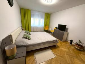 a small bedroom with a bed and a television at Ego Residence Alba Iulia in Alba Iulia