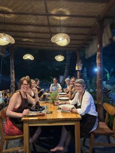 a group of people sitting at a wooden table at Bien dormir house in Sidemen +18 photos
