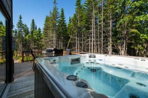 a jacuzzi tub on the deck of a house at Les Refuges du Massif de Charlevoix in Petite-Rivière-Saint-François
