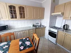 a kitchen with a dining table and a stove top oven at Nocleg przy Ratuszu in Pieniężno