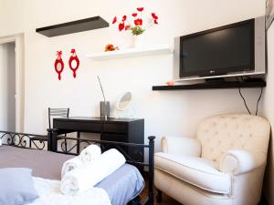 ローマにあるManzoni Holiday Apartmentのリビングルーム(テレビ、椅子付)