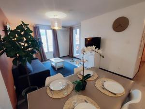 een woonkamer met een tafel en een bank bij L'Olivier - Piscine et climatisation in Gréoux-les-Bains