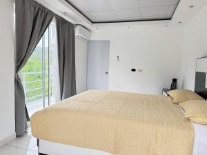 a bedroom with a large bed and a large window at villa el naciente in La Cuaba