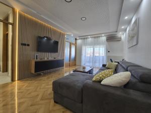 a living room with a couch and a flat screen tv at Apartman STRONG 2 in Slavonski Brod
