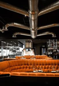 a row of orange leather seats in a restaurant at HO By Olivencia Paseo de Almeria 45 in Almería