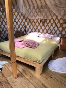 a small bed in a wooden igloo with at YURs in Baexem