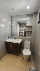 a bathroom with a sink and a toilet and a mirror at Mitropoleos Luxury Suites in Thessaloniki +58 photos