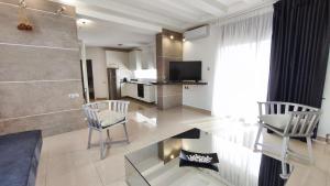 a living room with two chairs and a glass table at Mitropoleos Luxury Suites in Thessaloniki