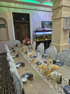 a long table in a room with a fish tank at HOTEL Rahmon - 2 in Samarkand