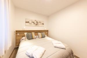 una camera da letto con un letto con asciugamani sopra di La Solana Apartaments & Spa a Encamp