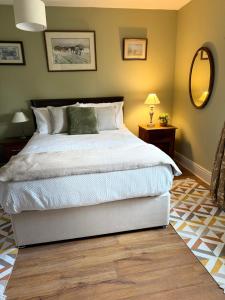a bedroom with a large bed and a mirror at Fennor Park Lodge in Oldcastle