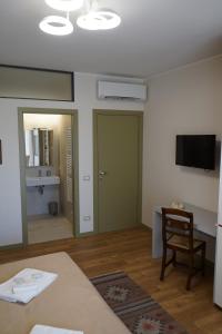 a living room with a table and a television at Avenue Rooms in Verona