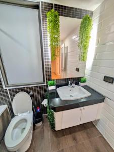 Un baño con un inodoro blanco y un lavabo. en Spacious and Renovated 1-Bedroom 100m to Nana BTS - 55 sqm, en Bangkok