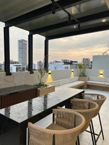 Luxury apartment with swimming pool in Equipetrol في سانتا كروز دي لا سيرا: فناء على طاولة وكراسي على السطح +42 صورة