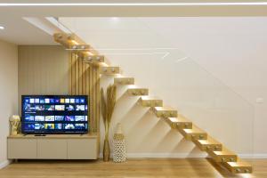 a staircase in a room with a tv and a stair case at Arial Lofts in Vlorë