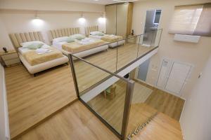 a room with two beds and a glass staircase at Arial Lofts in Vlorë