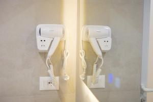 two white hair phones are hanging on a wall at Arial Lofts in Vlorë