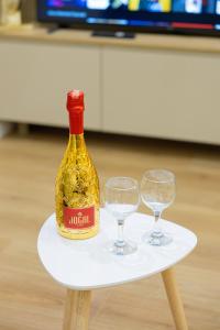 a bottle of wine on a table with two glasses at Arial Lofts in Vlorë