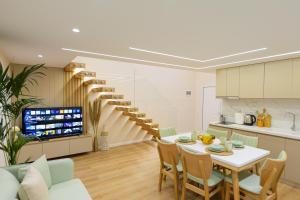 a kitchen and dining room with a table and a spiral staircase at Arial Lofts in Vlorë