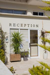 a white building with a sign that reads reception at Arial Lofts in Vlorë