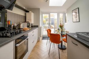 a kitchen with a stove and a table with chairs at Sleepers Cottage in Aldeburgh