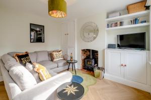 a living room with a couch and a fire place at Sleepers Cottage in Aldeburgh