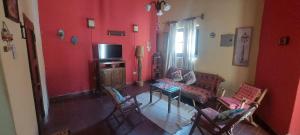 a living room with red walls and a table and chairs at Vidala in Tilcara +5 photos