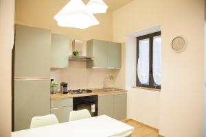 a kitchen with white cabinets and a white table and chairs at Santa Cesira in Mentana