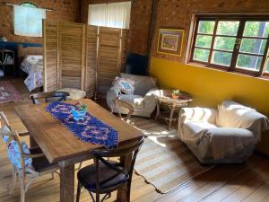 a living room with a table and chairs and a couch at Quarto do Cėu Terra Graciosa in Quatro Barras