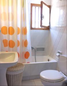 a bathroom with a toilet and a shower curtain at Traditional Maisonette House on the sea shore in Derveni