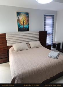 a bedroom with a bed with a painting on the wall at Hermoso Apartamento de 2 habitaciones en Avenida Bush in Santa Cruz de la Sierra