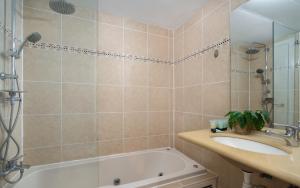 a bathroom with a tub and a sink and a shower at Pninat HaHoshen suite in Eilat +7 photos
