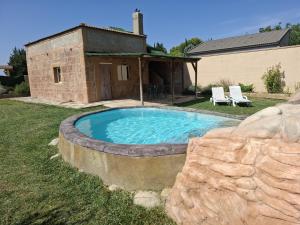 a swimming pool in a yard next to a house at Casa Noa in Huesca