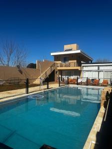 ein großes Schwimmbad vor einem Gebäude in der Unterkunft casa quincho concordia in Villa Zorraquín