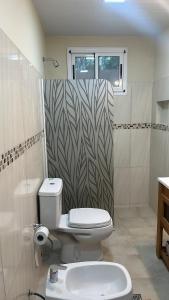 ein Badezimmer mit Toilette und Dusche in der Unterkunft casa quincho concordia in Villa Zorraquín
