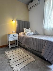 ein Schlafzimmer mit einem Bett mit einem Nachttisch und einem 6-dx-dx-Bett in der Unterkunft casa quincho concordia in Villa Zorraquín