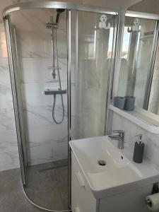 a white bathroom with a shower and a sink at Appartement 4 personnes in Vitry-sur-Seine