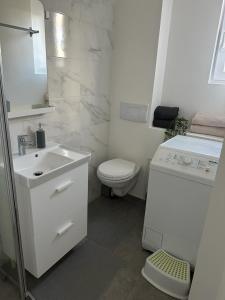 a white bathroom with a toilet and a sink at Appartement 4 personnes in Vitry-sur-Seine