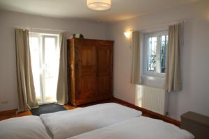 una camera da letto con due letti e due finestre di Ferienwohnung am Goldberg a Quirnheim