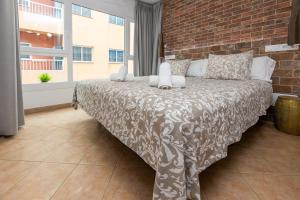 a bedroom with a bed with a brick wall at Calas Beach Corralejo in Corralejo