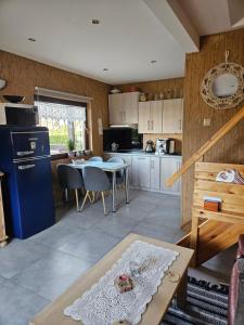 eine Küche mit einem Tisch und einem blauen Kühlschrank in der Unterkunft Grabówka in Nadole